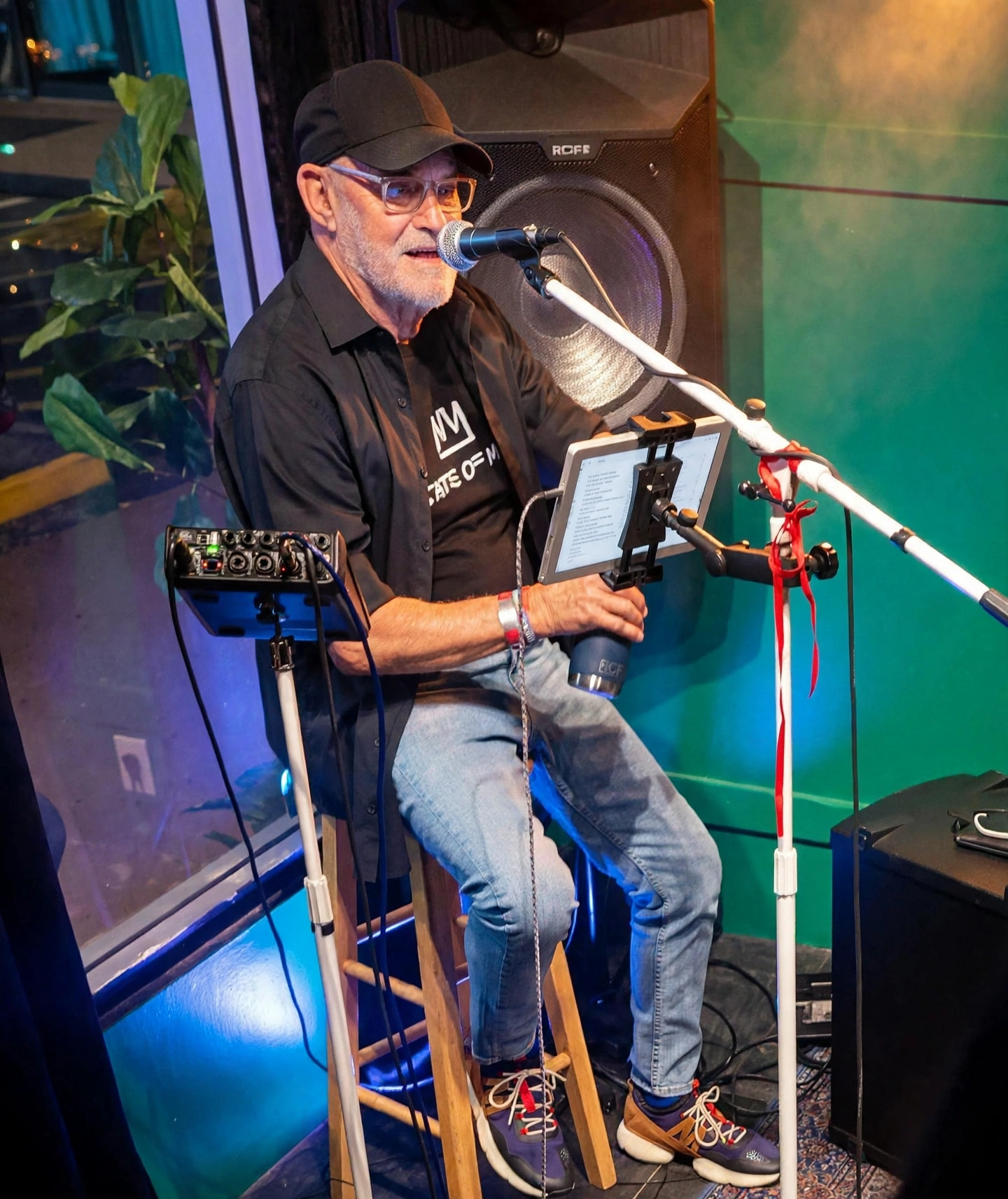 Live music at Jordan's Wine Bar — a performer singing into a microphone against a teal-lit wall